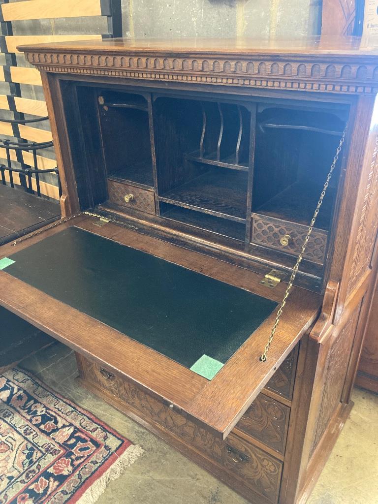 An Arts & Crafts oak escritoire, the cabinet was made out of oak shaft of the Taplow Court Mill Wheel (1845-1902) and presented by Edward Lodge in 1911, width 98cm, depth 52cm, height 122cm